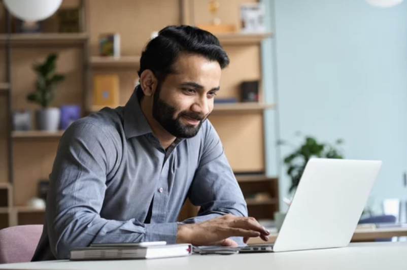 A male online tutor at work with his laptop