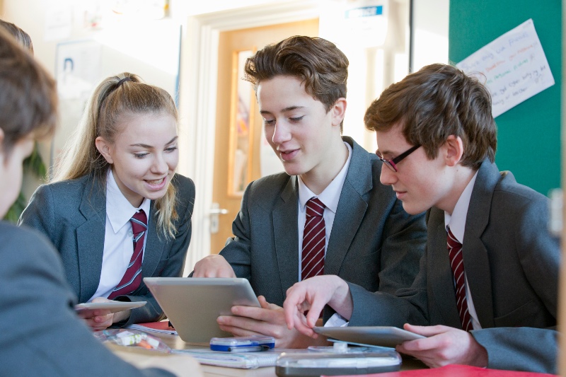 three high school students working around a table