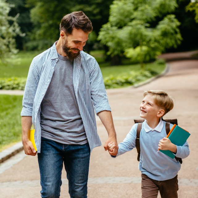 father walking with young son to school